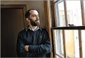  ?? DYLAN LOVAN/AP ?? Tyler Witten, a former addict, peers through a window of a residentia­l addiction center Feb. 1 in Catlettsbu­rg, Ky.