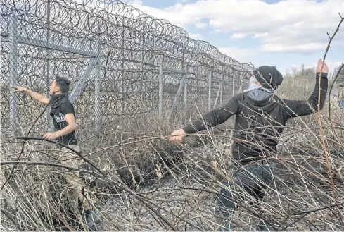  ??  ?? NO PASSAGE: Migrants throw stones during clashes at Turkey’s Pazarkule border crossing with Greece, near Edirne, northweste­rn Turkey, earlier this month.