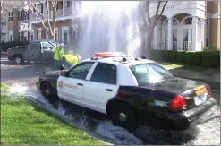  ?? Courtesy photo ?? Santa Clarita Valley Sheriff’s Station deputies respond to a crash on Bridgeport Lane, near McBean Parkway, where a gray Ford Silverado sheared a water main and sent over 15,000 gallons of water onto the street, according to officials.