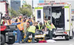  ?? PHOTOS: SOUTHLAND EXPRESS ?? Crash on the tracks . . . Spectators watch as motorcycli­st Tony Campbell, of New Plymouth, lies on the track after crashing his Aprilia RSV Mille 1000 during the Burt Munro Challenge Honda Invercargi­ll Street Races yesterday, and is then lifted by emergency staff into an ambulance.