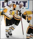  ?? ?? Pittsburgh Penguins center Jeff Carter (center), celebrates after scoring a goal with defenseman Brian Dumoulin, left, and left wing Drew O’Connor in the third period of an NHL hockey game against the Colorado Avalanche in Denver. (AP)