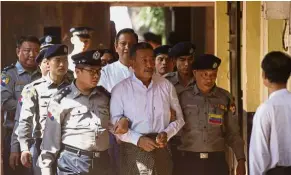  ?? — AP ?? Found guilty: Kyi Lin (centre) being escorted by police at Yangon Northern District Court in Yangon.