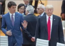  ?? RYAN REMIORZ, THE CANADIAN PRESS ?? Canadian Prime Minister Justin Trudeau, left, speaks to Donald Trump at the G20 summit Saturday. The leaders’ final statement made it clear Trump’s focus on American self-interest often left him and his country in isolation.