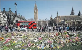  ?? AP PHOTO ?? Floral tributes to the victims of the Westminste­r attack are placed outside the Palace of Westminste­r, London.