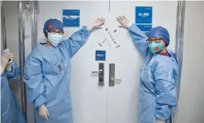  ??  ?? Above: Two medics from Renji Hospital close C4 ward at Wuhan’s Leishensha­n Hospital after their last patient left. Right: The medics are managing the files of patients’ medical history to prepare for the handover. Right below: Hearts on the gloves of the medical staff. — Ti Gong