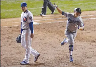  ?? The Associated Press ?? Los Angeles Dodgers’ Enrique Hernandez, right, celebrates as he runs bases after hitting a grand slam against the Chicago Cubs during the third inning of Game 5 of their National League Championsh­ip Series on Thursday in Chicago. At left is Cubs first...