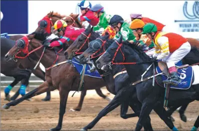  ?? XIONG QI / XINHUA ?? Jockeys compete in a race this year in Wuhan, Hubei province, where the local government is trying to build the country’s horse racing capital.