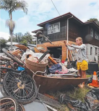  ?? Picture: GLENN HAMPSON ?? Residents clean up in Uki after the devastatio­n wreaked by Cyclone Debbie.