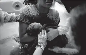  ?? Erin Schaff/New York Times ?? Midwives hand a new mom her baby to hold for the first time at a birthing center in Argyle. State health officials say they need more time to finish the maternal mortality report.