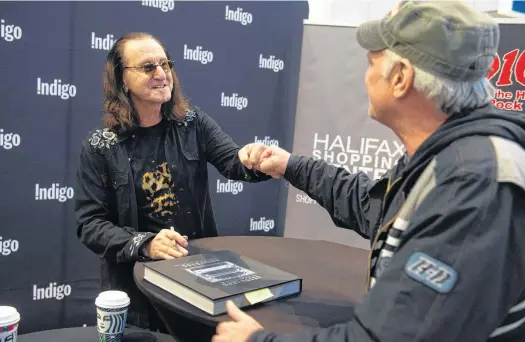  ?? RYAN TAPLIN • THE CHRONICLE HERALD ?? Jon Freeland meets with Geddy Lee, the legendary bassist and singer for Rush, at the Halifax Shopping Centre on Saturday. Lee was in Halifax to sign copies of his new book The Big Beautiful Book of Bass on Saturday. The hardcover book is more than 400 pages and showcases Lee's bass collection.