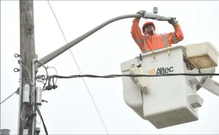  ?? PETER LEE, RECORD STAFF ?? Darcy Rink of Fairway Electrical installs an LED light on Francis Street in Kitchener on Thursday.