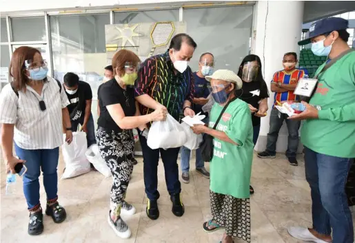  ?? (Pampanga PIO) ?? ASSISTANCE FOR SCAVENGERS. Gov. Dennis Pineda, assisted by PDRRMO chief Angie Blanco, distribute­s assistance to scavengers who were vaccinated last Friday at the Bren Z. Guiao Convention Center in the City of San Fernando.