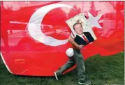  ?? GORAN TOMASEVIC / REUTERS ?? A supporter of Turkish President Recep Tayyip Erdogan carries his picture beside a Turkish flag in front of the ruling AK Party’s headquarte­rs in Istanbul on Sunday.