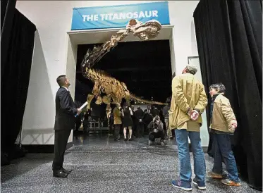  ??  ?? Giant among its peers: Visitors examining a replica of the 37m-long Patagotita­n mayorum on display at the American Museum of Natural History in New York. — AP