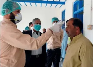  ?? AFP ?? SUSPECTS’ SCREENING: A doctor checks the body temperatur­e of a man returning from Iran at a quarantine zone to test for the coronaviru­s in the border town of Taftan. —