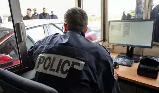  ?? ?? A French police o  cer checks passports and vehicles at the entrance of the Channel tunnel in Calais, northern France