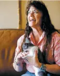  ?? GABRIELA CAMPOS THE NEW MEXICAN ?? Gigi Mitchell holds Midge the kitten Thursday at her home. Mitchell bottle-fed Midge as a baby and will foster her to make sure the kitten is behaving normally after she was stolen from an adoption room at Petco this week.