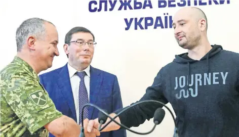  ??  ?? El periodista ruso Arkady Babchenko (der.), saluda al fiscal general Yuriy Lutsenko (centro) y al jefe de los servicios de seguridad estatales (SBU) Vasily Gritsak, en Kiev.