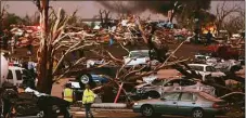  ?? Associated Press ?? In this May 22, 2011, file photo, emergency personnel walk through a severely damaged neighborho­od after a tornado hit Joplin, Mo.