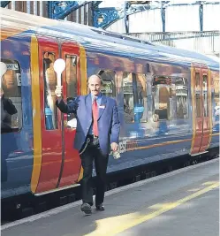  ??  ?? A South West employee prepares for a train’s departure.