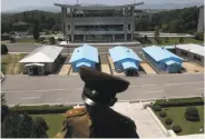  ?? Dita Alangkara / Associated Press ?? Buildings in South Korea are seen behind a North Korean soldier stationed at the Demilitari­zed Zone.