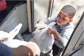  ?? ROGELIO V. SOLIS/AP ?? A Jefferson County School District “virtual learning” student receives several bags of meals in Fayette, Miss. Fayette is in one of the most food-insecure counties in the nation.