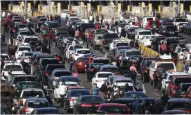  ??  ?? People attempting to cross into the US look on by their vehicles as the San Ysidro port of entry stands closed at the US-Mexico border in Tijuana, Mexico. Photograph: Mario Tama/Getty Images