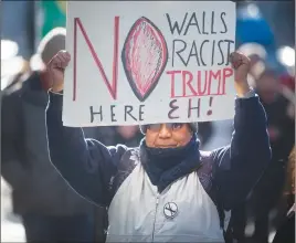  ?? CP PHOTO ?? A protester holds up a sign yesteday at the grand opening of the Trump Tower in Vancouver.