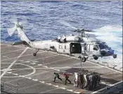  ?? MC Darion Chanelle Triplett U.S. Navy ?? A NAVY helicopter delivers cargo to the U.S. aircraft carrier Abraham Lincoln in the Persian Gulf.