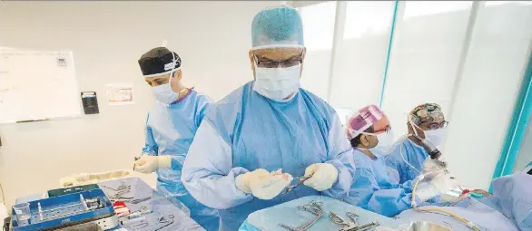  ?? ARLEN REDEKOP ?? Dr. Amin Javer, second from right, and his team perform sinus surgery on a patient at Vancouver’s False Creek Surgical Centre.