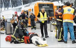  ?? Adrian Quiroga ?? The Associated Press An injured passenger is attended to on the platform of a train station Friday in Barcelona, Spain. Dozens of people were injured when a morning commuter train they were traveling on crashed into the buffers in a station in...