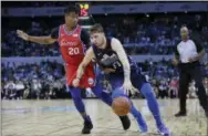  ?? KIN CHEUNG — THE ASSOCIATED PRESS ?? Luka Doncic of the Dallas Mavericks, right, drives past the Sixers’ Markelle Fultz during Monday’s game in China.