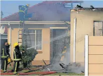  ??  ?? BURNT OUT: Firefighte­rs douse the fire at a house in Woolhope Road, Westering, which was gutted