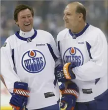  ?? ASSOCIATED PRESS FILE PHOTO ?? Wayne Gretzky’s protector for many years, Dave Semenko is pictured, right, with “The Great One” at a practice for the National Hockey League’s Heritage Classic Alumni game last Oct. 21.