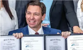  ?? Photograph: Cristóbal Herrera/EPA ?? Governor Ron DeSantis signs legislatio­n on teachers including banning automatic union deductions from paychecks, in Miami on 9 May.