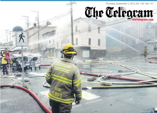  ?? — Photo by James Mcleod/the Telegram ?? Firefighte­rs attack a stubborn blaze Wednesday that left three downtown buildings in ruins at the corner of Duckworth Street and Bates Hill in St. John’s.