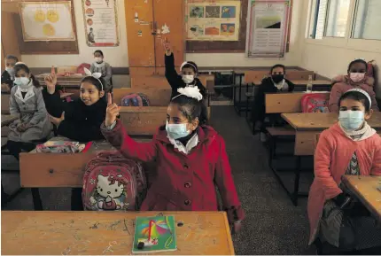  ?? AFP PHOTO ?? BACK IN SCHOOL
Mask-clad Palestinia­n pupils attend a class amid the coronaviru­s pandemic at a school run by the United Nations in the Nuseirat refugee camp in the Gaza Strip on February 27, 2021.