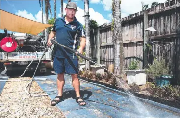  ??  ?? GETTING BLASTED: John Giarrusso of Top Gun Business exterior cleaning service gives a driveway the treatment as people give their properties some extra care. Picture: BRENDAN RADKE