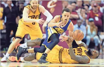  ?? BOB DONNAN, USA TODAY SPORTS ?? Cavaliers forward and four-time NBA MVP LeBron James, on his back, battles Warriors guard Stephen Curry, this season’s MVP, for a loose ball in Tuesday’s Game 3.