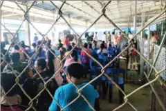  ?? MARYANN BYLANDER ?? Cambodian migrant workers wait at Poipet’s immigratio­n office on Friday, after trucks full of workers were deported by Thai authoritie­s back to the Kingdom.