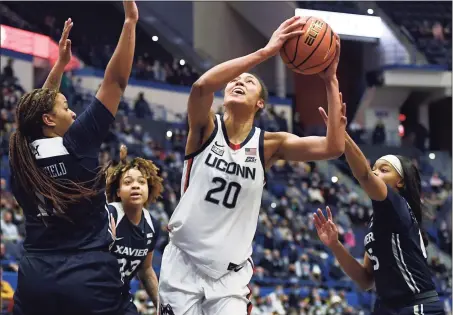  ?? Jessica Hill / Associated Press ?? UConn’s Olivia Nelson-Ododa (20) shoots between Xavier's Kae Satterfiel­d, left, and Mackayla Scarlett during the first half on Saturday.