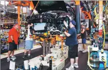  ?? BILL PUGLIANO / GETTY IMAGES ?? General Motors workers assemble a Cadillac on the assembly line at the Lansing Grand River Assembly Plant in Lansing, Michigan.