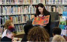  ??  ?? Sandra Collins, executive director and founder of enGender, reads a book to campers at the Bay Area Rainbow Day Camp in El Cerrito, Calif. Collins says, A lot of these kids have been bullied and had trauma at school. This is a world where none of that...