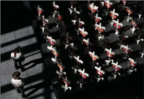  ?? John Locher/AP ?? Memorial: People look at a display of wooden crosses and a Star of David on display at the Clark County Government Center in Las Vegas. The crosses and Star of David had been part of a makeshift memorial along the Las Vegas Strip erected in memory of the victims of the Oct. 1, 2017, mass shooting in Las Vegas.