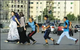  ?? ASSOCIATED PRESS ?? In this Aug. 20, 2012 file photo, an Egyptian youth, trailed by his friends, gropes a woman crossing the street with her friends in Cairo, Egypt.