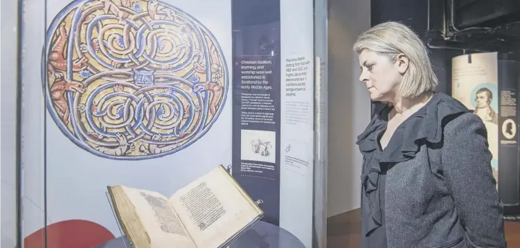  ?? ?? Chief Executive and National Librarian, Amina Shah, admires the Iona Psalter which dates from between 1180 and 1220. It contains sacred songs known as psalms