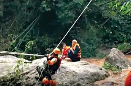  ??  ?? Momento em que as duas jovens são retiradas da cascata por uma equipa de resgate, na Tailândia