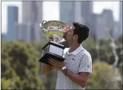  ?? DITA ALANGKARA — THE ASSOCIATED PRESS ?? Serbia’s Novak Djokovic kisses his trophy, the Norman Brookes Challenge Cup, during a photo shoot at Melbourne’s Royal Botanic Gardens following his win over Austria’s Dominic Thiem in the men’s singles final at the Australian Open tennis championsh­ips, in Melbourne, Australia, Monday.