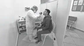  ?? VASILY MAXIMOV/AFP VIA GETTY IMAGES ?? Medical worker takes a saliva sample at a drive-in COVID-19 testing facility in Moscow, Russia, on May 2.