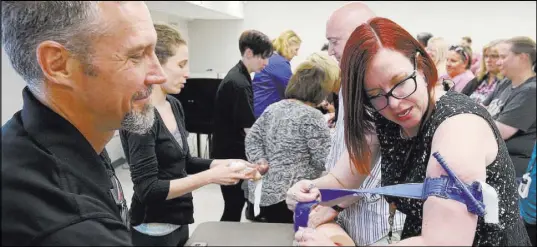  ?? K.M. Cannon Las Vegas Review-Journal @KMCannonPh­oto ?? Las Vegas Academy teacher Eva Williams learns how to apply a tourniquet with John Maholick during University Medical Center’s “Stop the Bleed” training.